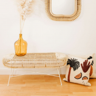 Banc JAVA BLANC en rotin et métal blanc sous un miroir, avec un vase ambré